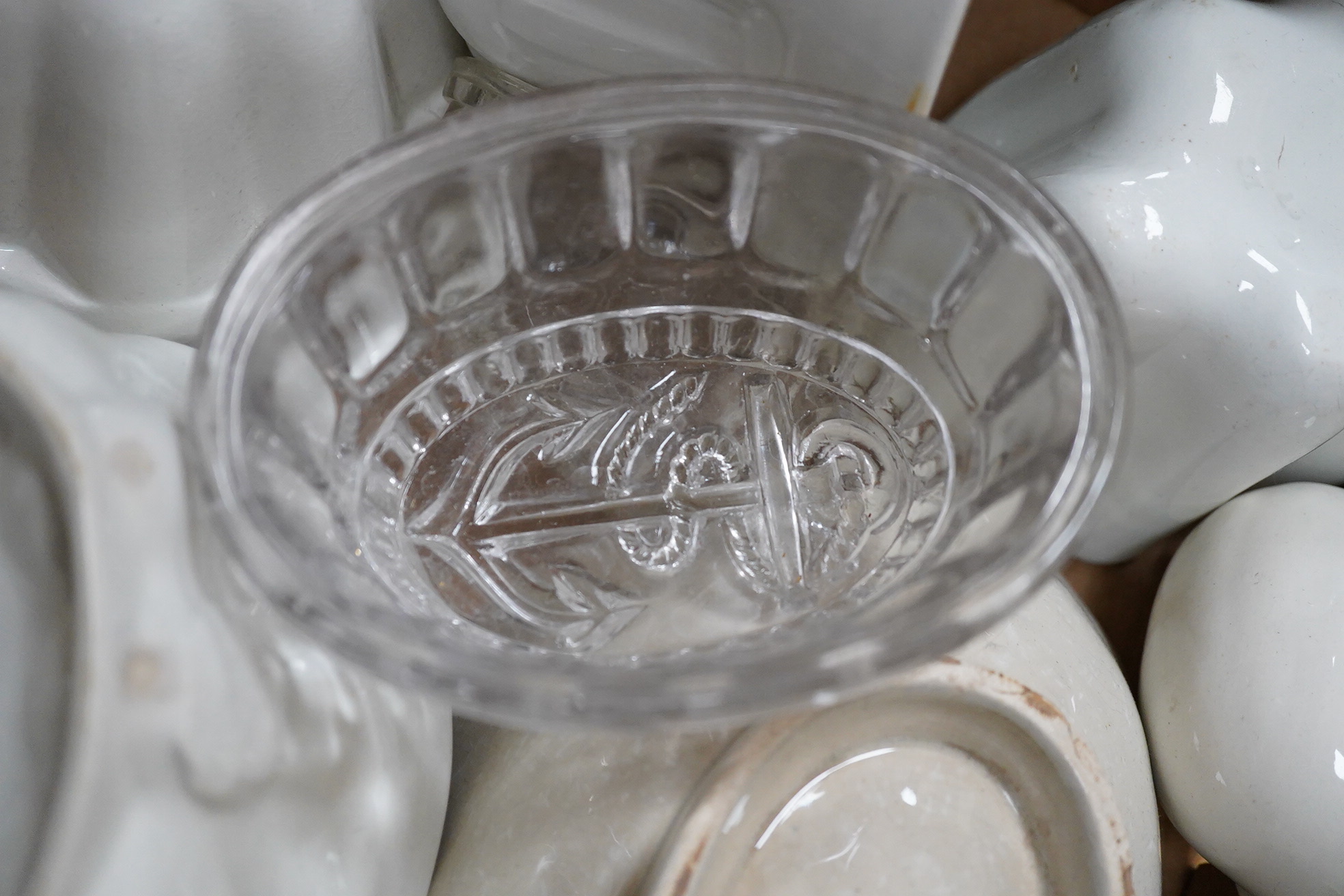 A collection of mostly Victorian ceramic and later glass and metal jelly moulds